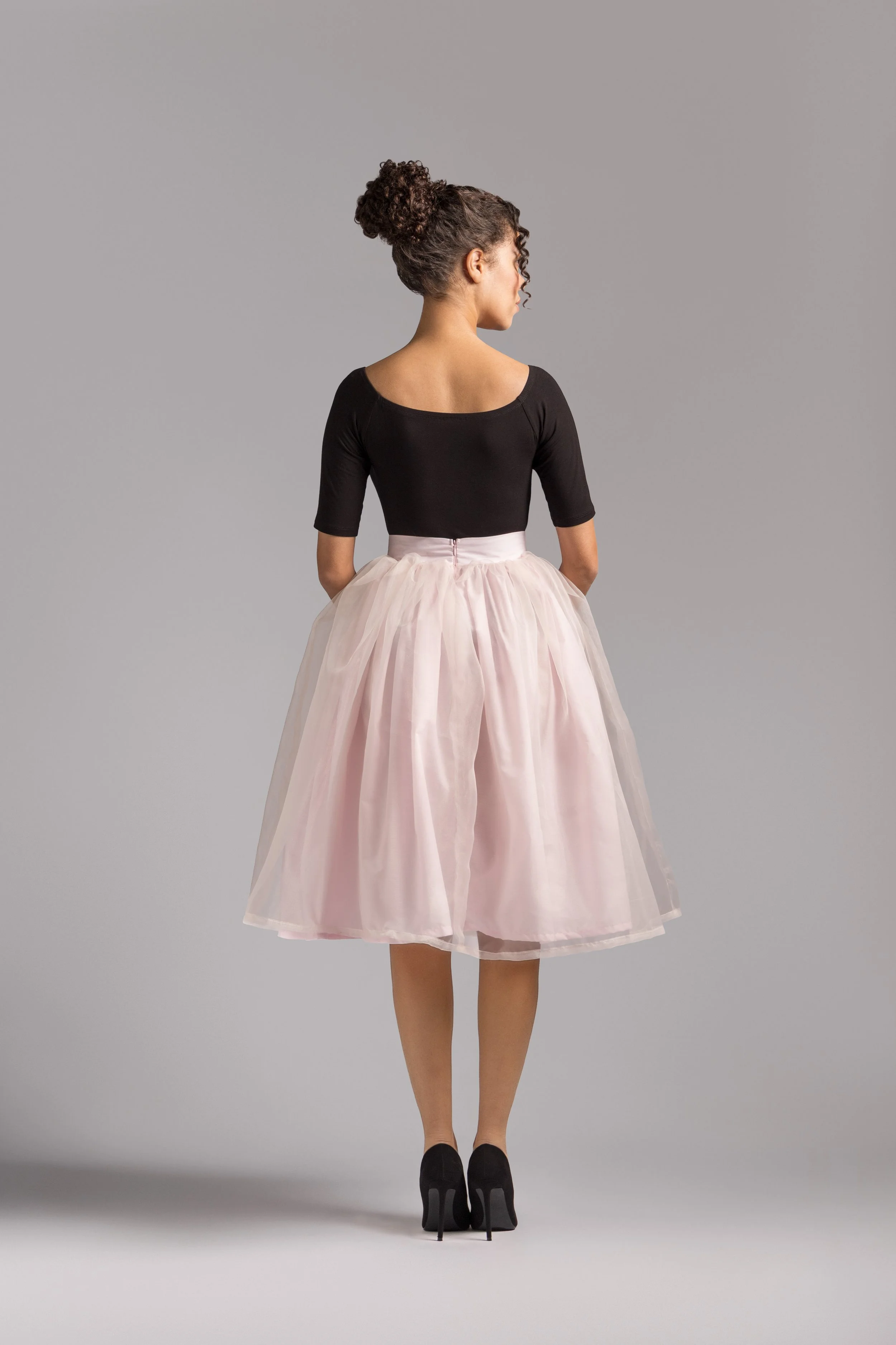 Model wearing an ivory organza midi skirt featuring a voluminous ballerina-inspired silhouette.