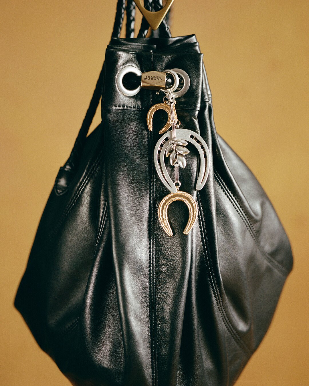 Isabel Marant black leather bag featuring decorative charms and metal accents embodying contemporary Parisian bohemian fashion