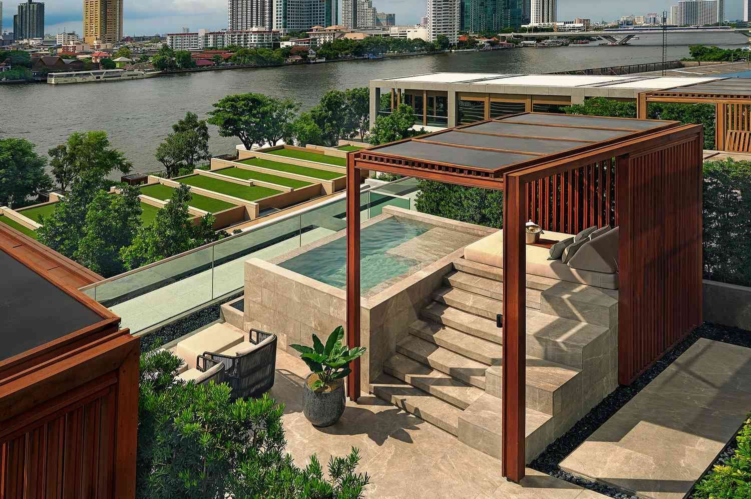 Riverside private villa at Capella Bangkok with plunge pool, wooden cabana, and views of the Chao Phraya River and city skyline.