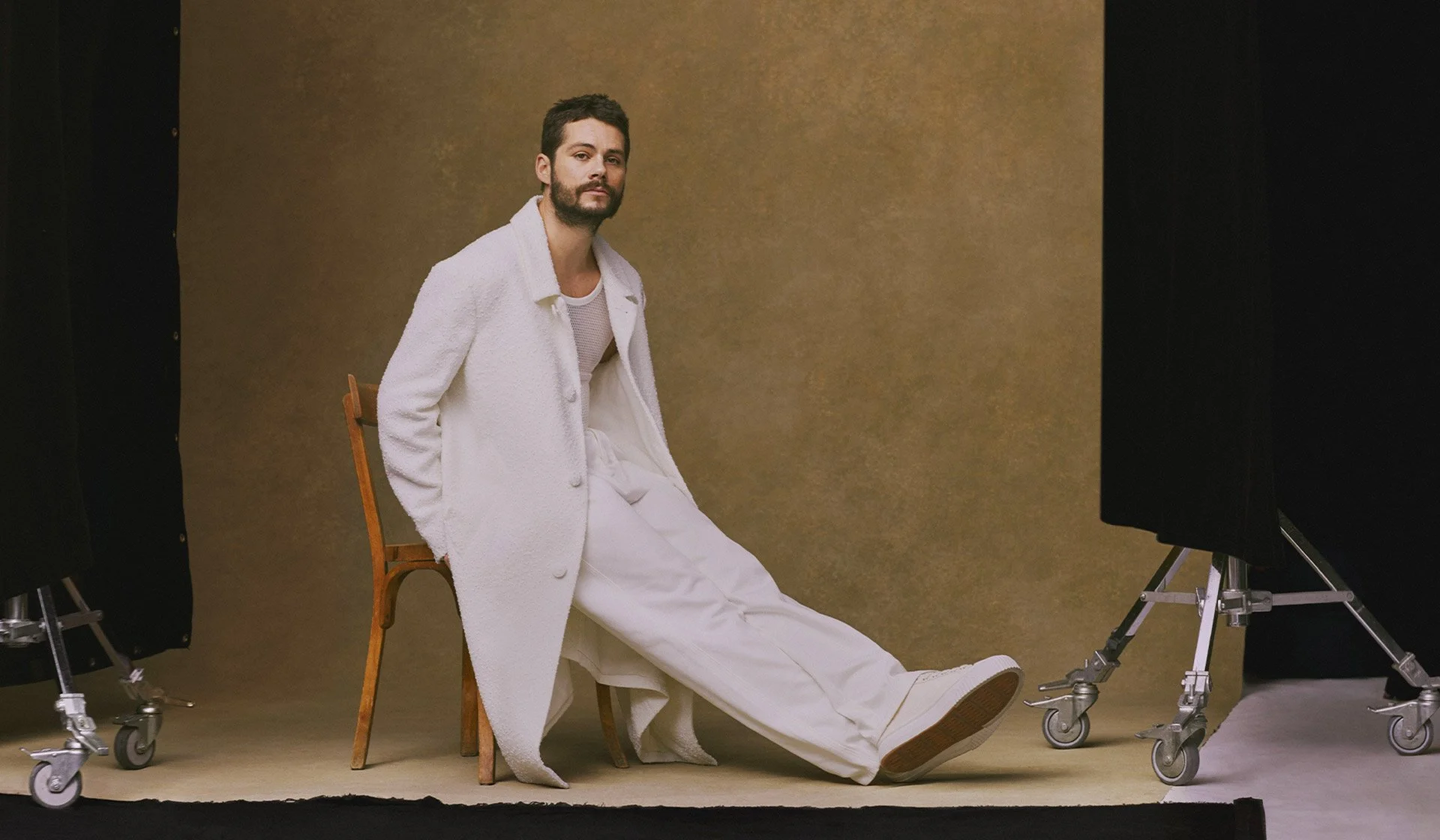 AMI Paris menswear campaign featuring a model in a minimalist studio wearing an all white look that reflects the brand’s relaxed Parisian tailoring and contemporary elegance