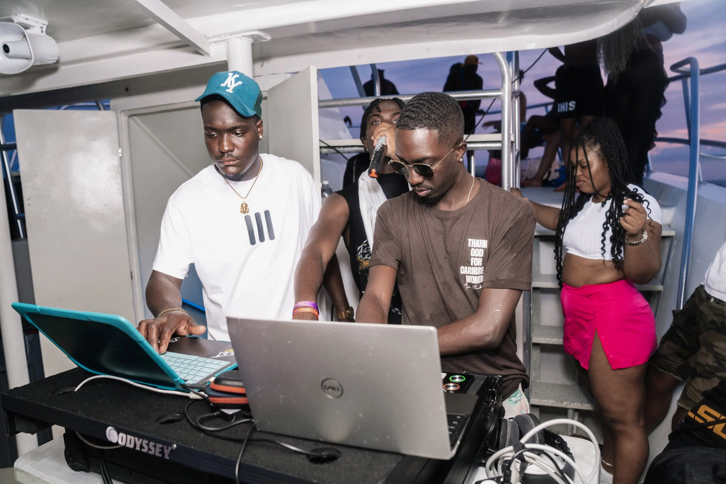 A group of people DJing and dancing on a boat cruise during sunset. Sea Sand Soca