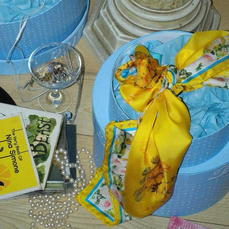 Golden Hour Fátoli Silk Scarf displayed on the floor.