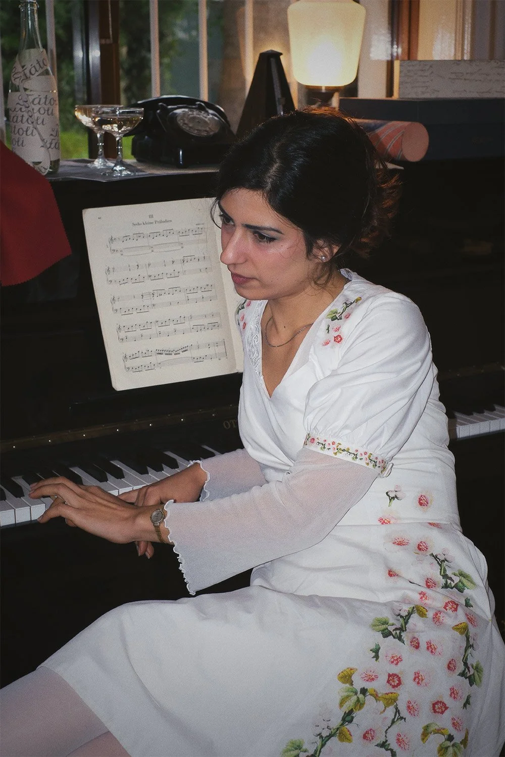 Clarisse wearing pacha dress next to the piano.