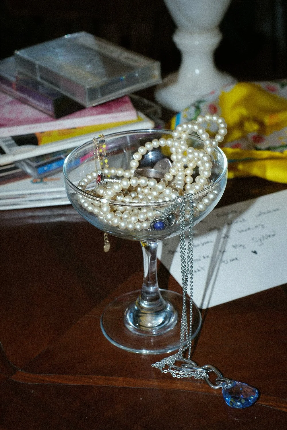 Coupe glass full of pearls and rings.