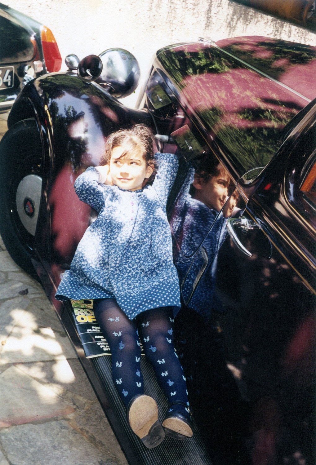 Clarisse as a child, sunbathing in the car.