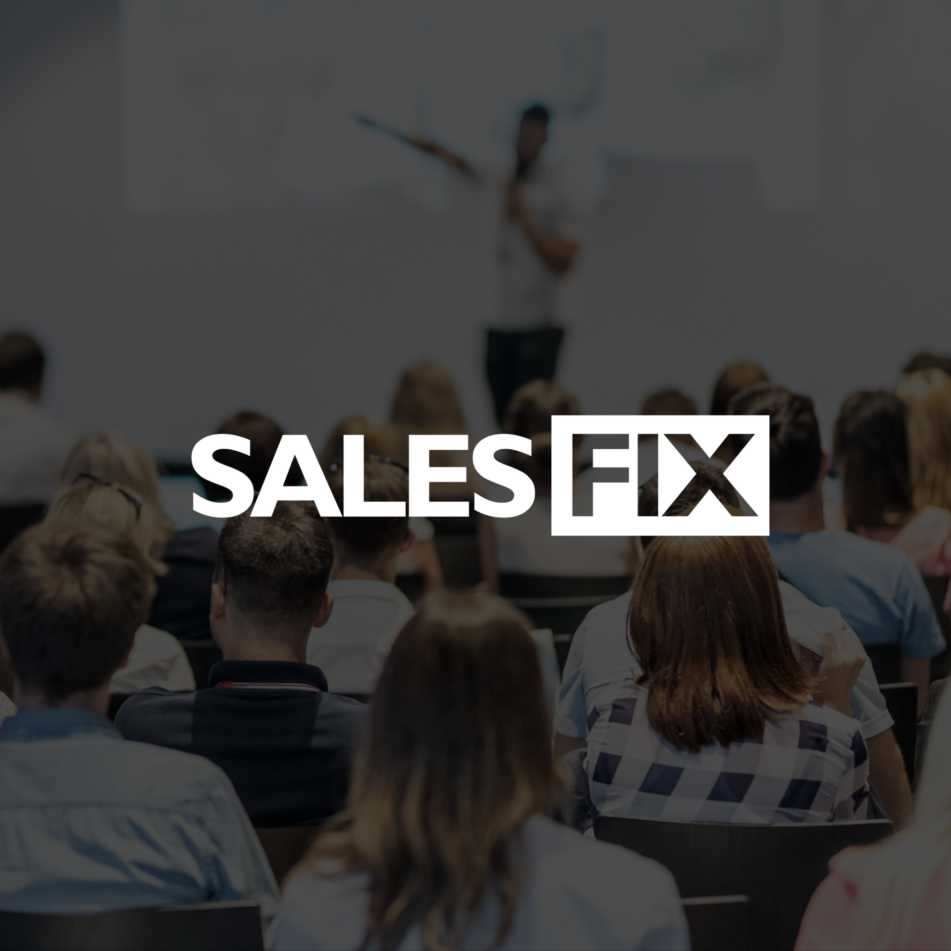 Audience attending a presentation in a conference room with a speaker at the front.