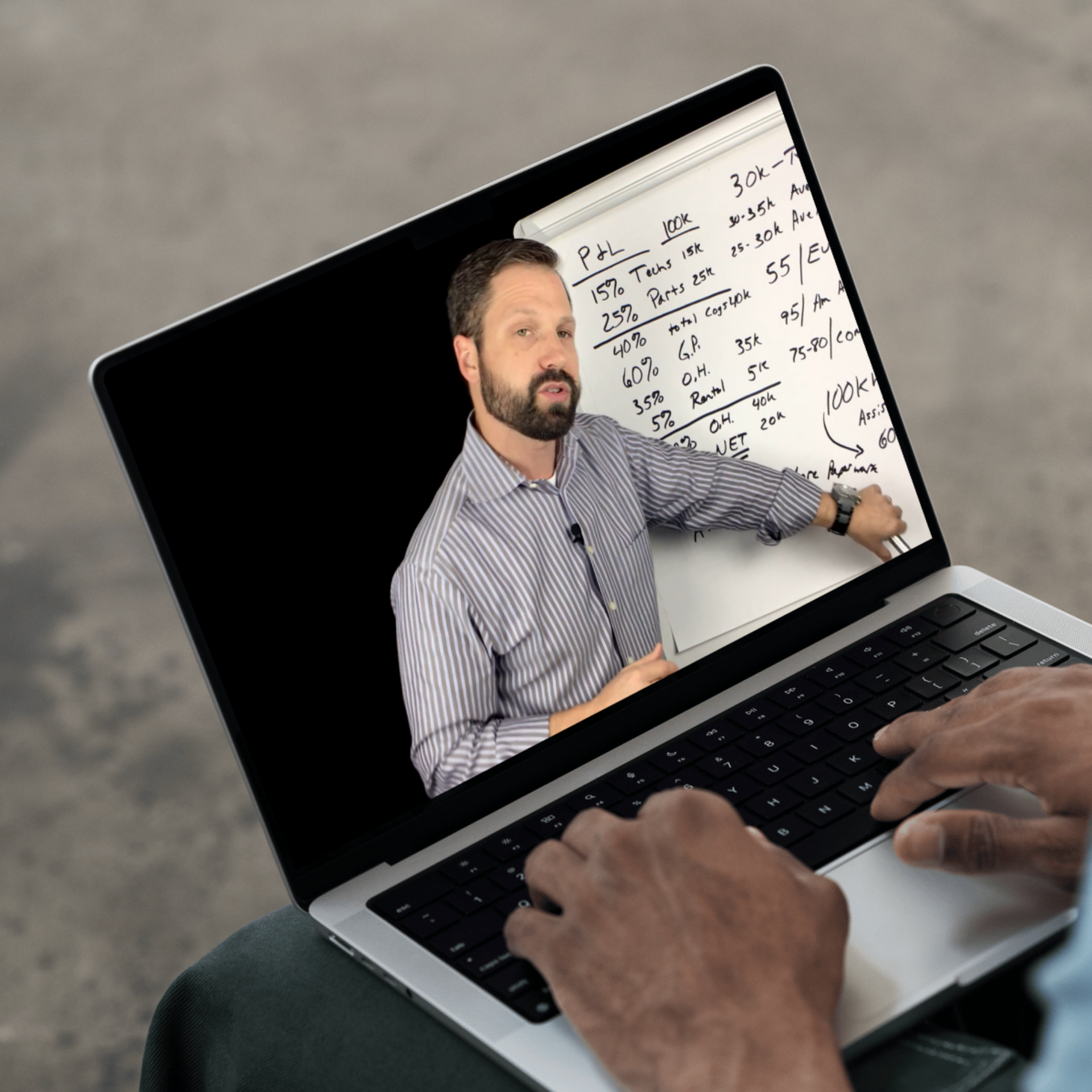 A person using a laptop, with a video of a man giving a presentation on the screen, showing handwritten notes on a whiteboard.
