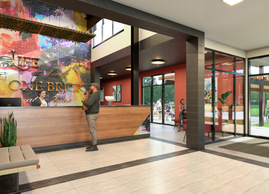 Modern lobby with a reception desk, people interacting, and colorful wall art in a communal area.
