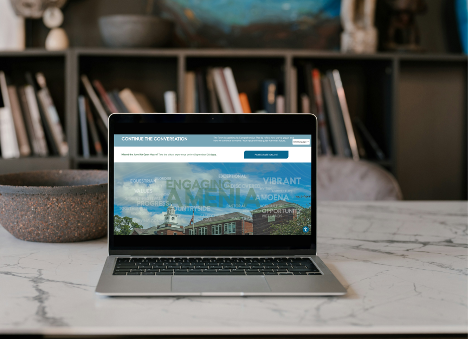 Laptop on a marble table displaying a website related to community engagement, with a bookshelf in the background.