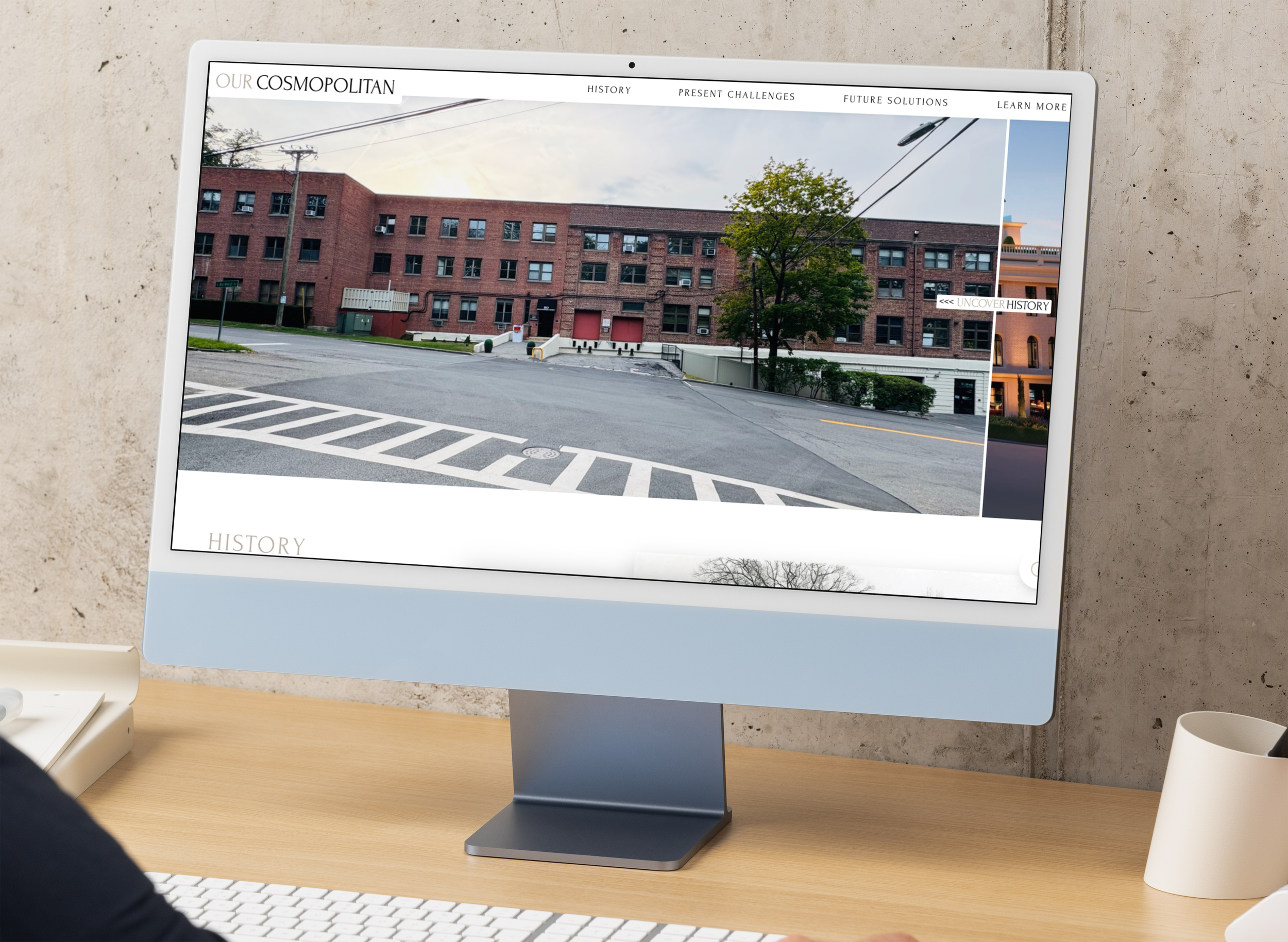 Computer screen displaying a website titled 'Our Cosmopolitan' with a photo of a street and brick building, and menu options at the top.