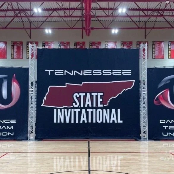 Basketball gymnasium with a large banner reading Tennessee State Invitational, featuring an outline of the state of Tennessee.