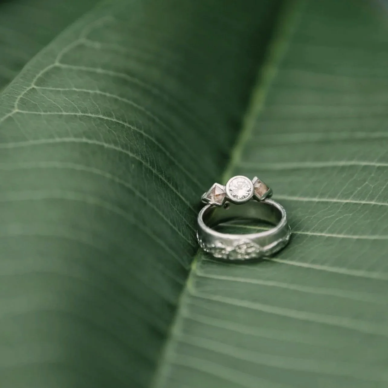 Platinum wedding rings.  Hers with heirloom stone and pink rustics. His with carvings of Telluride mountains and Baja waves