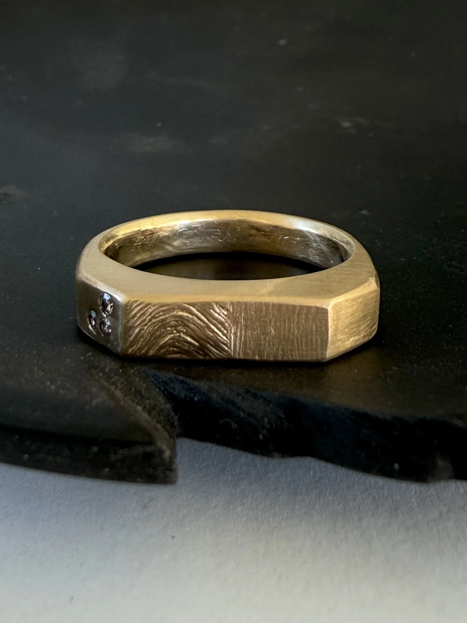 A wedding band rework for a couple who still love each other even if not together. You can still see the engraving on the inside, some family stones, their daughters fingerprint.  