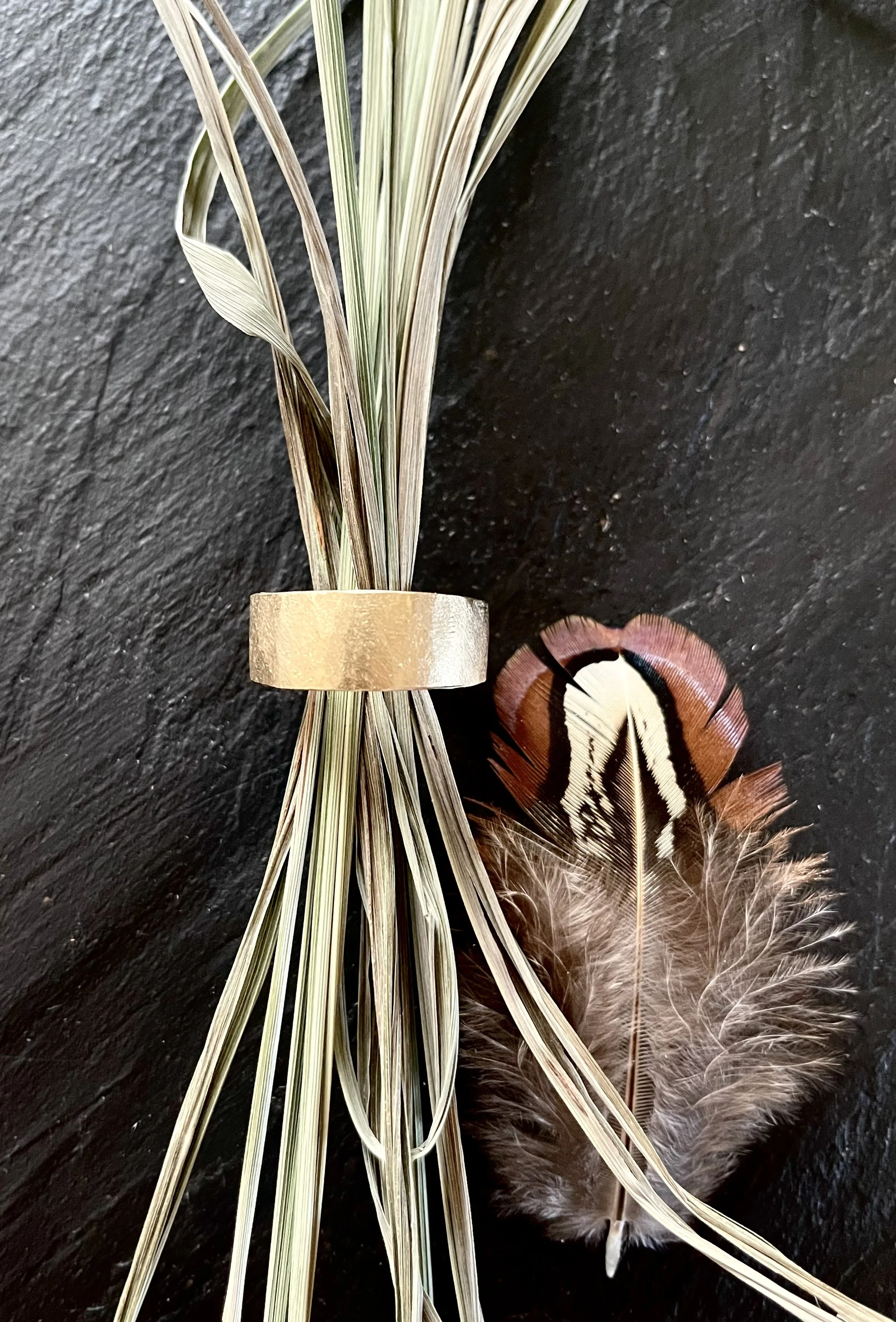 Hand carved 14K gold tapered men's band with black diamond and hammered texture.