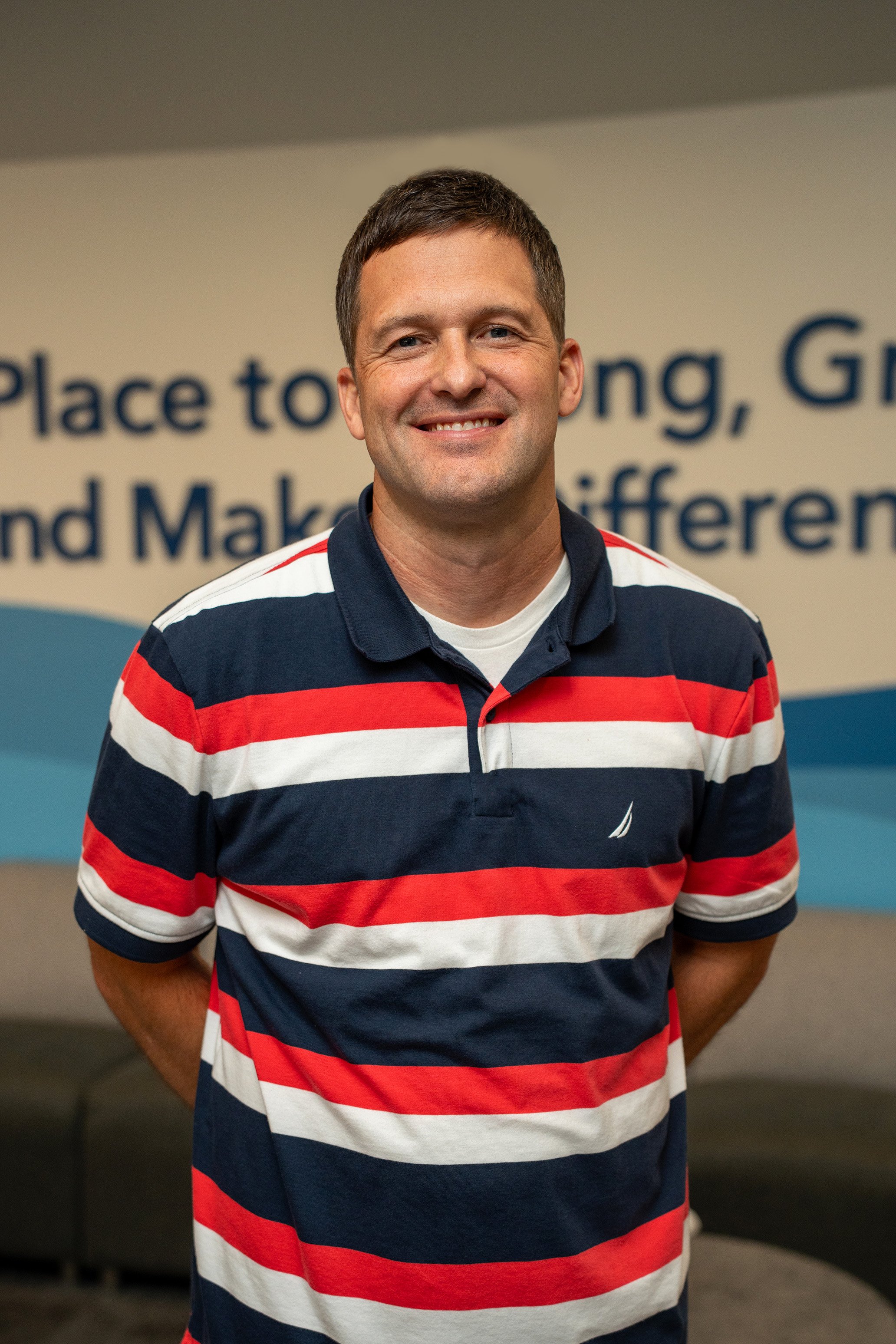 Joshua Hahn, Senior Minister and Elder at The Fountain in Fountaintown, Indiana, smiling in the church lobby. Providing expository preaching and biblical leadership as part of the church’s mission to help people grow and serve.