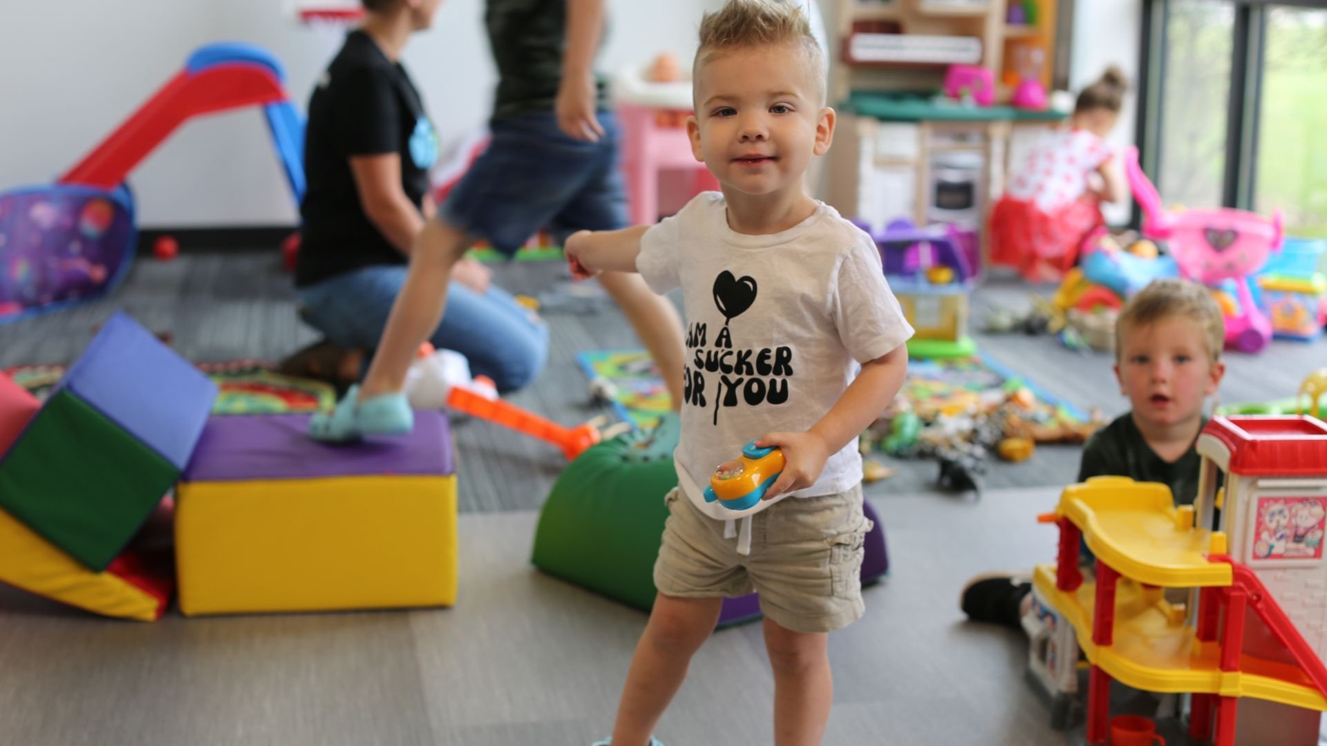 Smiling preschooler holding a toy in the nursery at The Fountain during Sunday morning children’s ministry in Fountaintown, Indiana. Safe, welcoming environment for birth through Pre-K during 9:30 and 11 AM church services.
