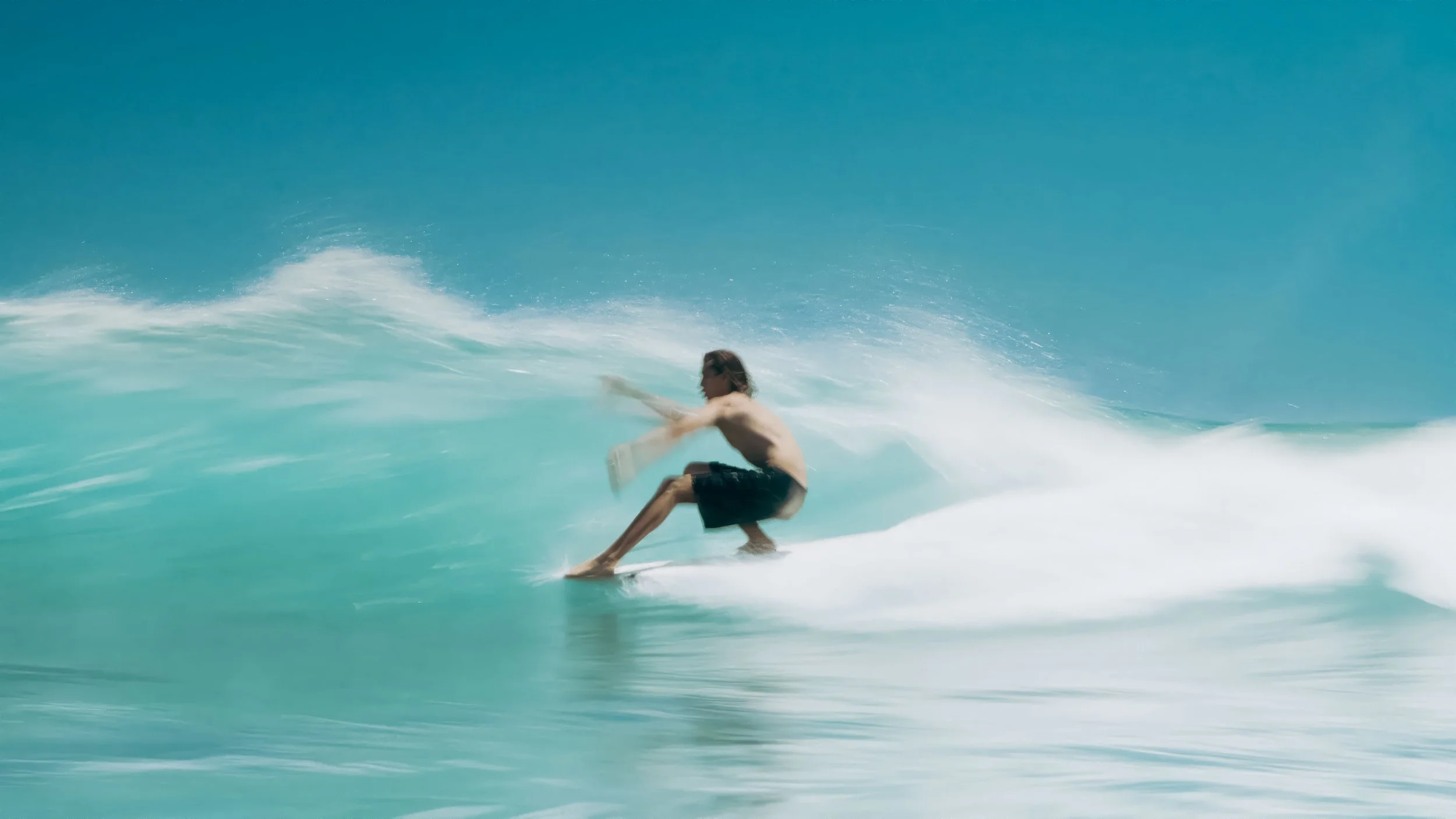 A longboard surfer glides along a perfectly peeling right-hand wave at Malibu Surfrider Beach, California. Captured from the water by Aquasnaps, this in-water surf photograph showcases the timeless style of traditional longboarding