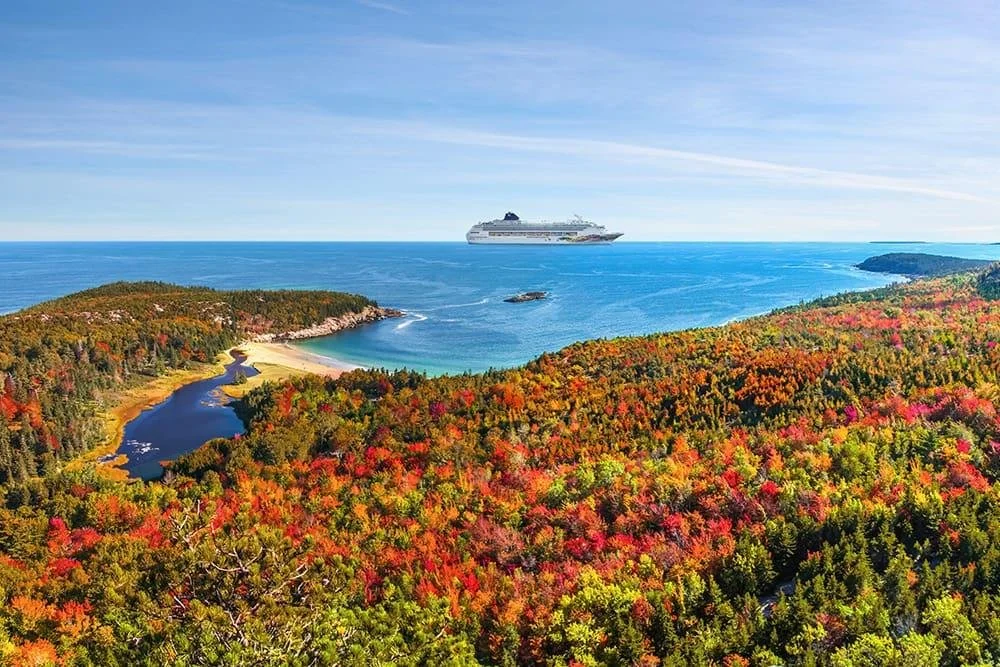 Cruise ship sailing along the colorful coast of Canada and New England during fall.