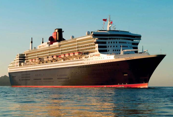 Large cruise ship with multiple decks and flags on the water at sunset.