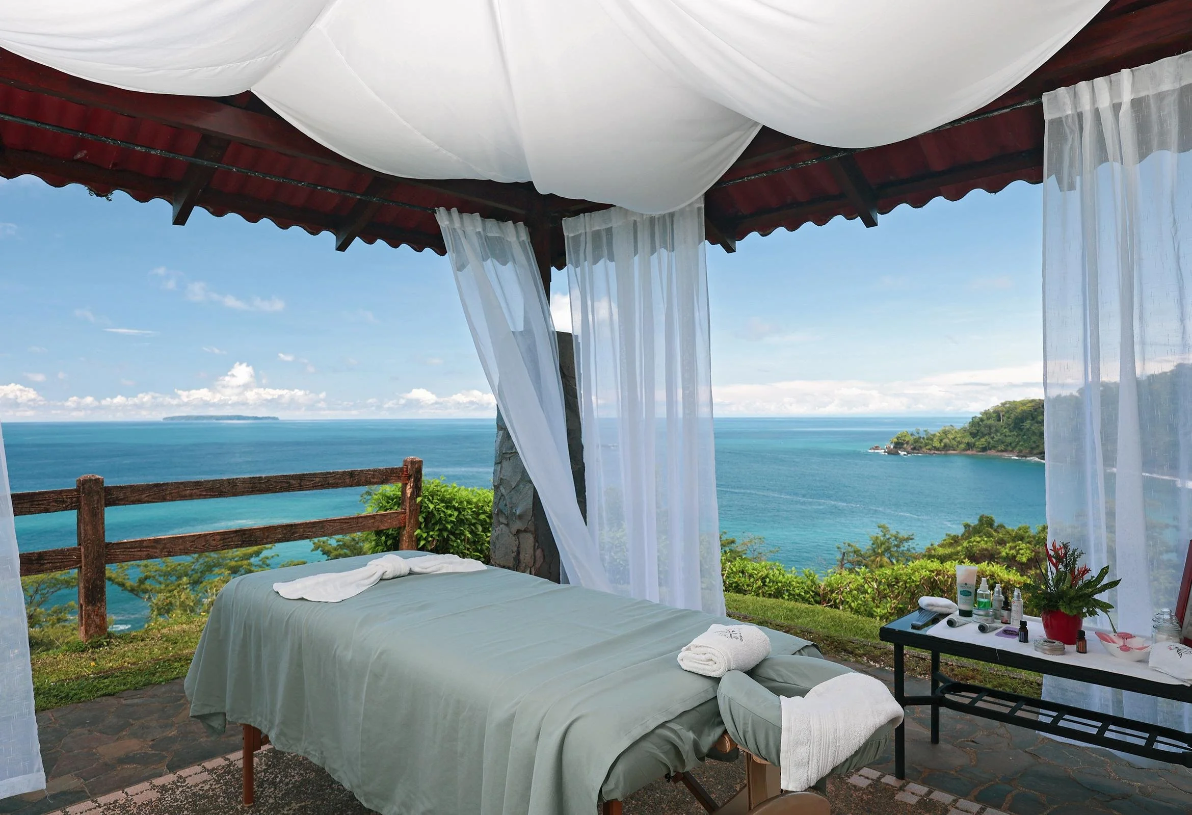 Open-air spa treatment area at SCP Corcovado Wilderness Lodge overlooking the turquoise Pacific Ocean and lush Costa Rican coastline.