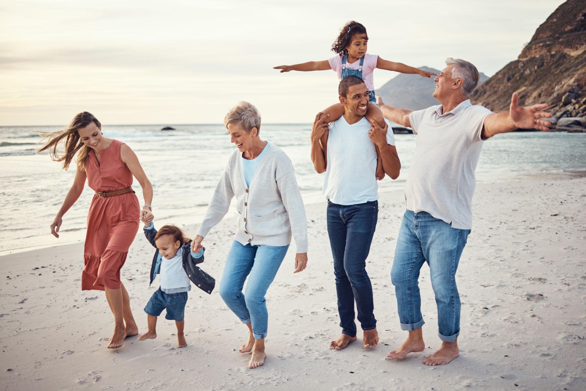 Grandparents, parents, and children enjoying a beach vacation together.