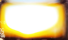 Bright, blurry light with a yellow and white glow, no discernible objects.