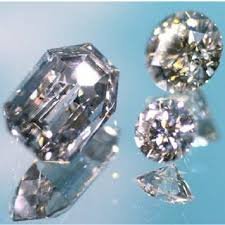 Three loose diamonds and a diamond fragment on a blue background.