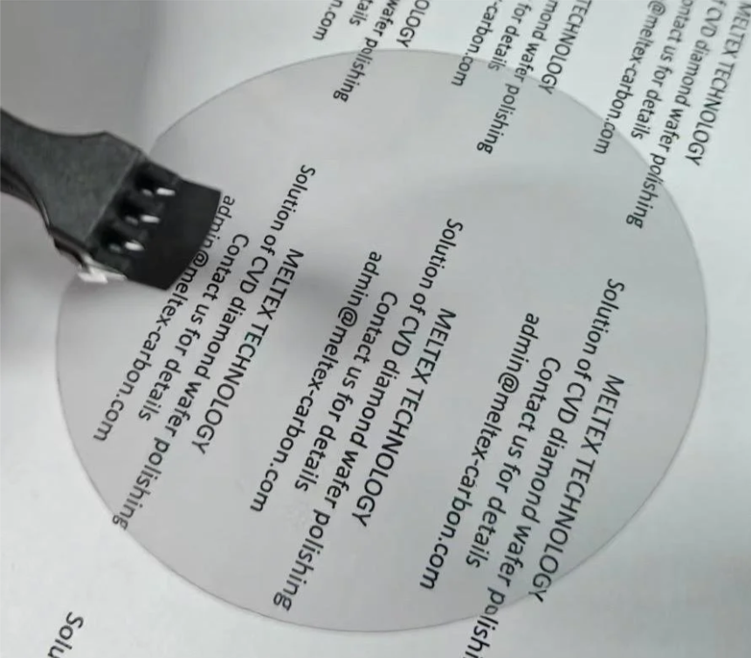 Close-up of a black plastic tunica connector cable on a printed business card or sheet of paper.