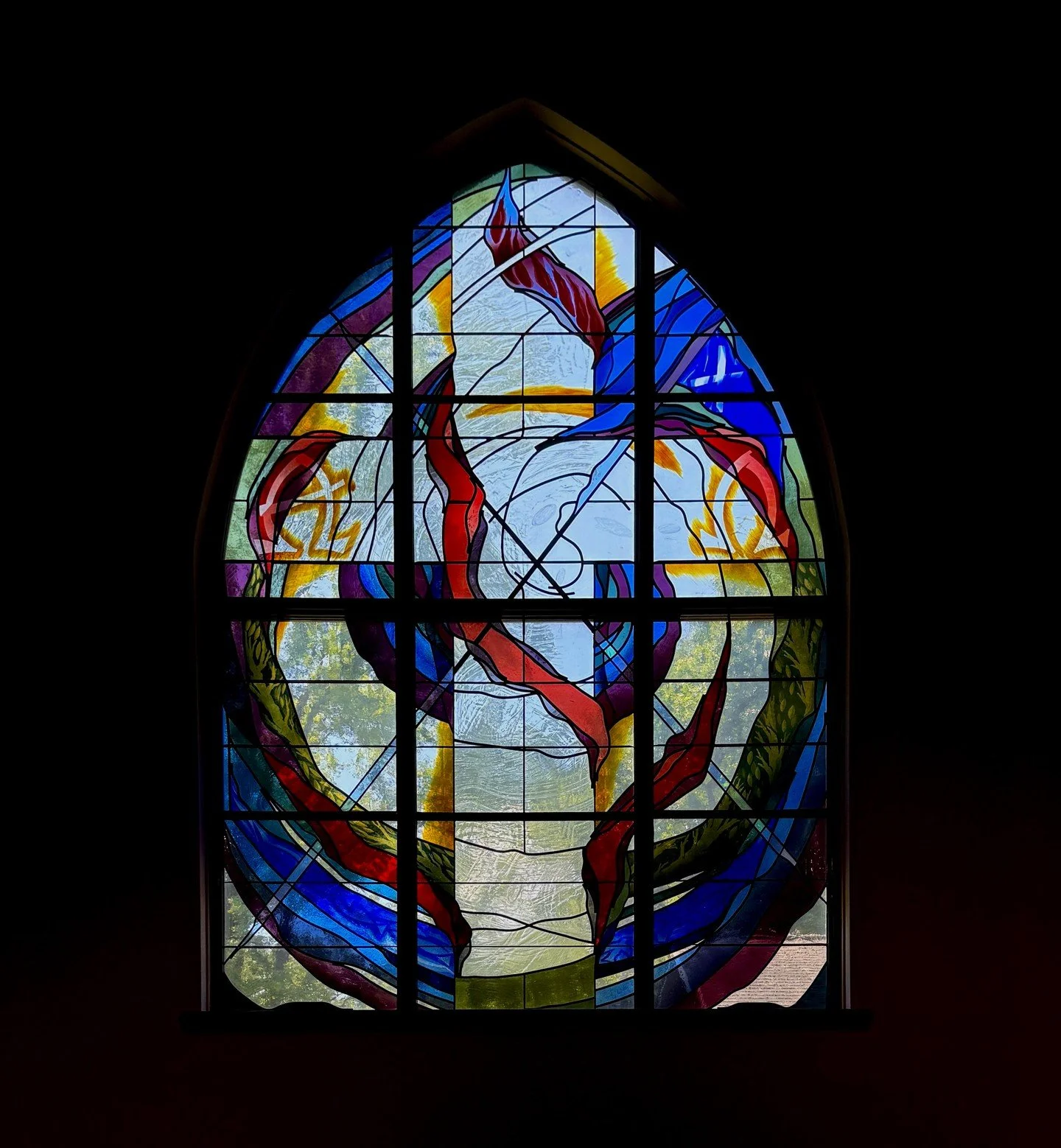 The Creation window at the Episcopal Church of the Creator in Clinton, MS features a striking spiral that unifies the three panels into a cohesive visual statement. This non-traditional symbol represents the divine forces that brought the world into