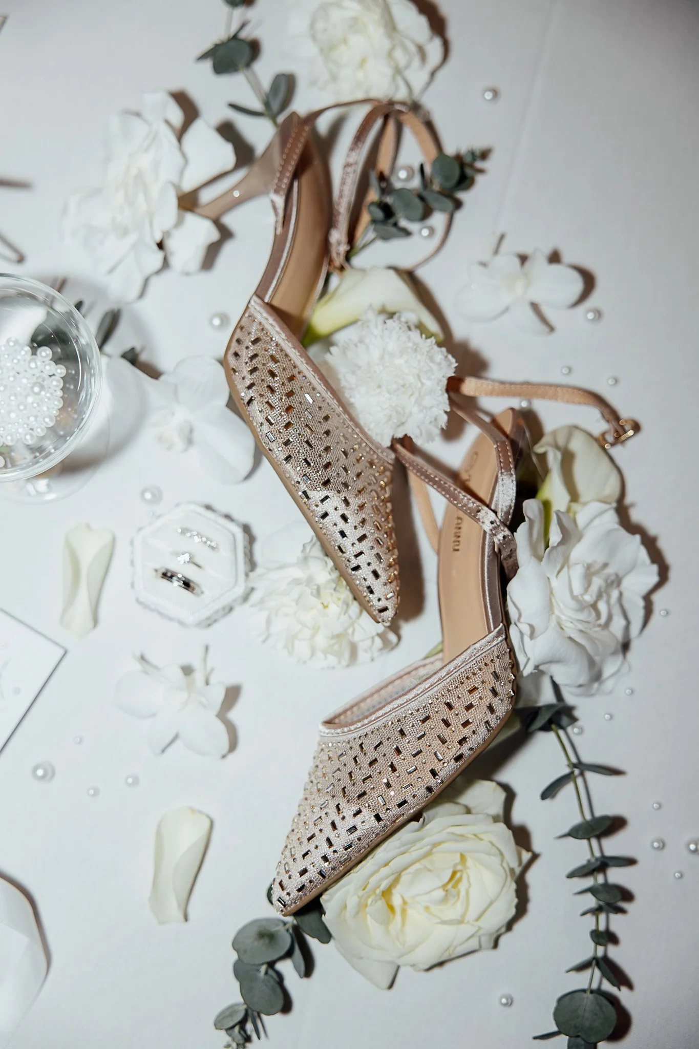 Bridal accessories and shoes styled in a neutral flat lay for a modern wedding shoot.