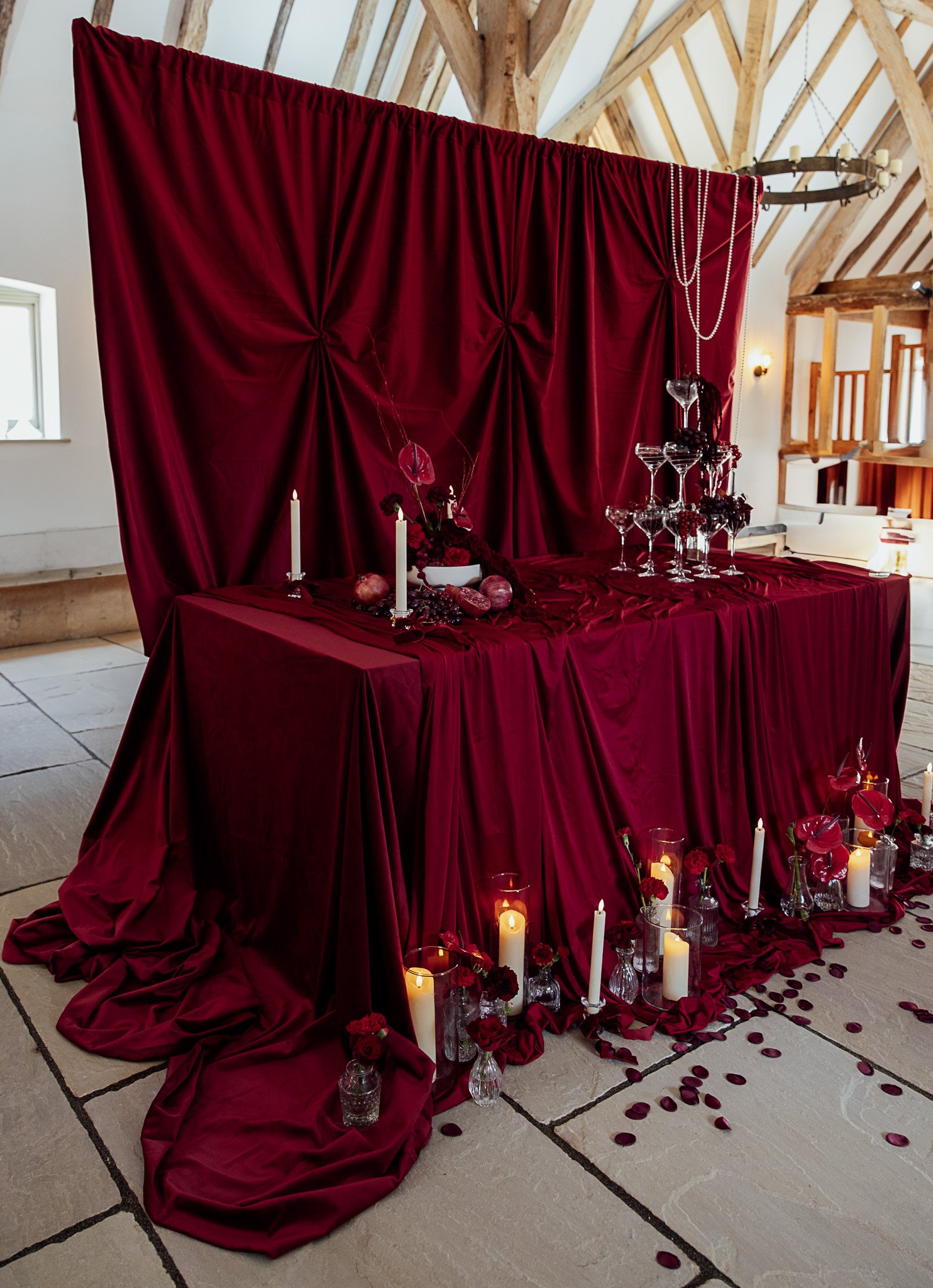 Dramatic red wedding tablescape setup inside Byre Barn Kent wedding venue