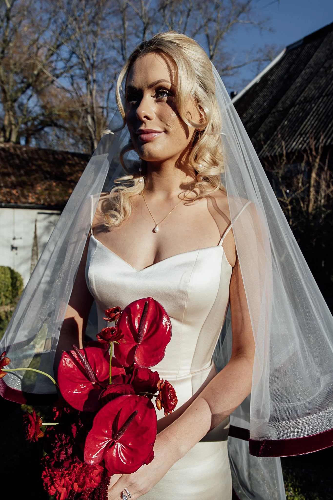 Modern bridal portrait holding red florals at Byre Barn Kent wedding styled shoot
