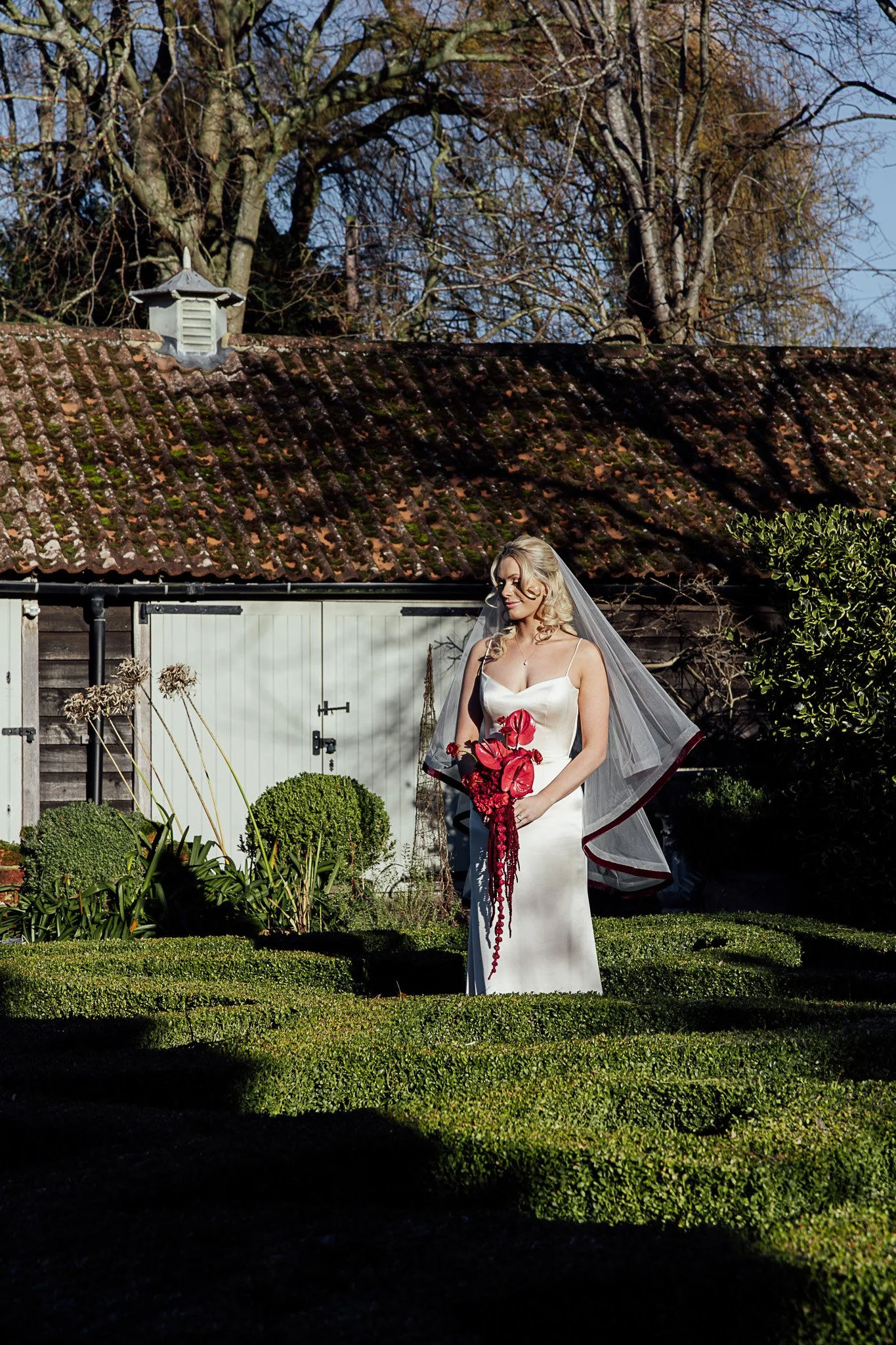Bride standing in the grounds of Byre Barn Kent with contemporary wedding bouquet