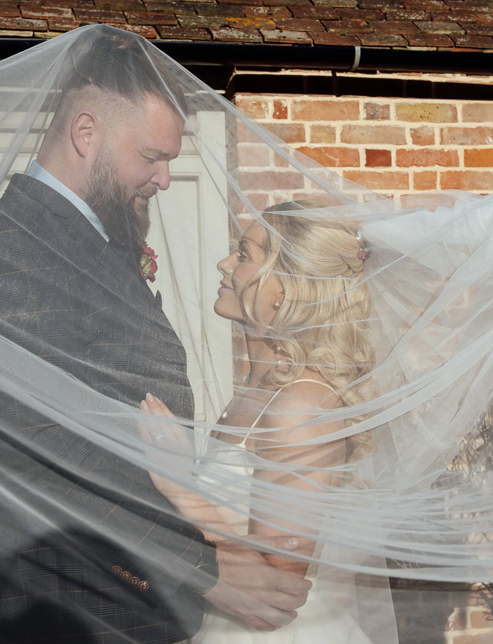Romantic couple portrait beneath veil at Byre Barn Kent wedding venue