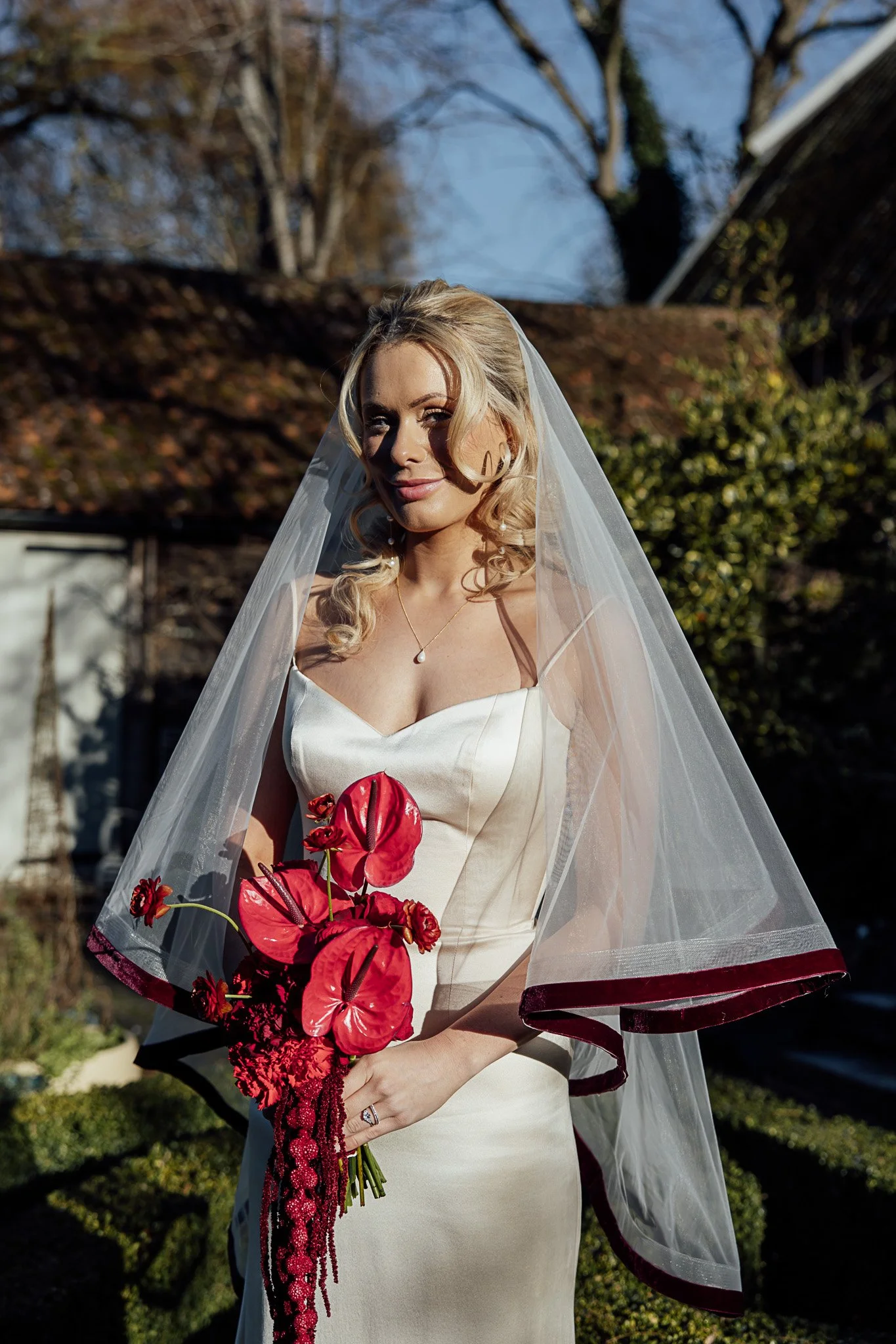 Modern bridal portrait with red floral bouquet at Byre Barn Kent styled shoot