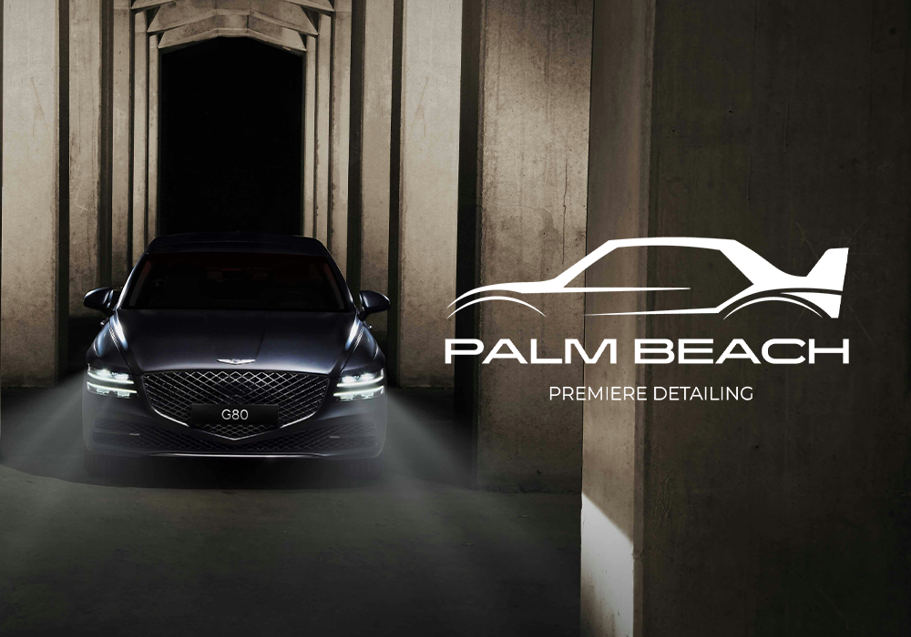 A sleek black car with illuminated headlights parked in front of an architectural structure, with a logo of a car outline and palm trees, and the text 'PALM BEACH PREMIÈRE DETAILING'.