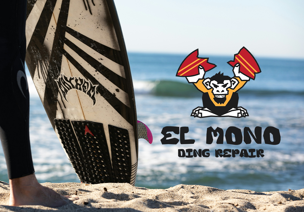 A person on the beach holding a used surfboard with a logo of a lion holding two red and yellow axes, and the text 'SC MONO DING REPAIR' next to it.