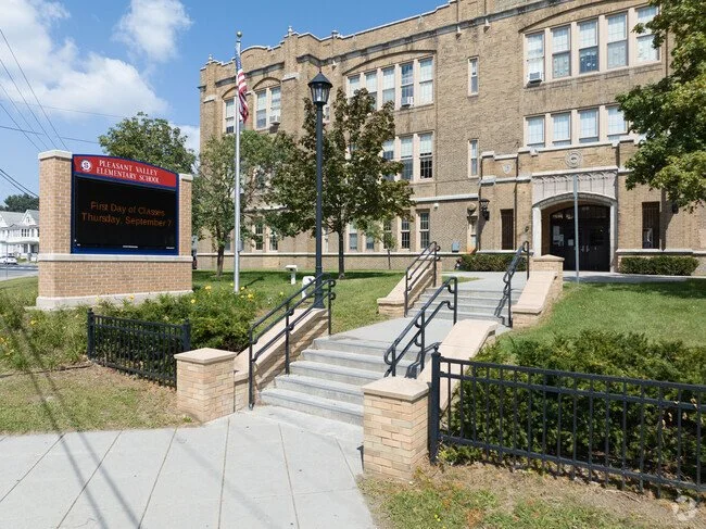 Entrance to Pleasant Valley Elementary School with stairs, ramp, and a sign indicating first day of classes.