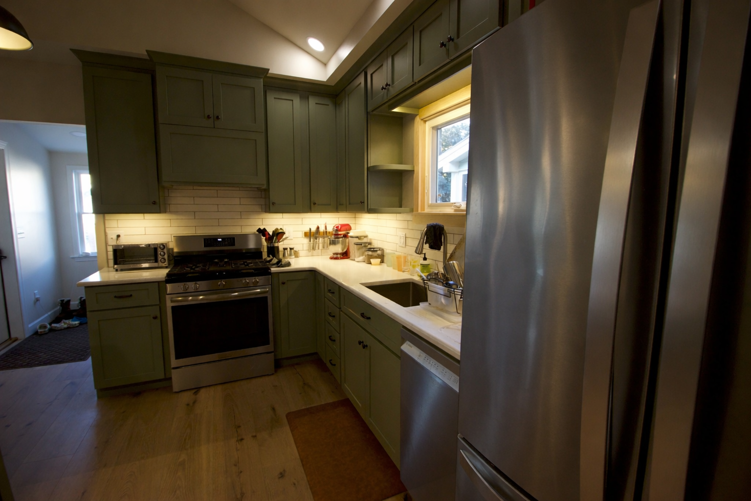 Sage green kitchen with stainless appliances.png