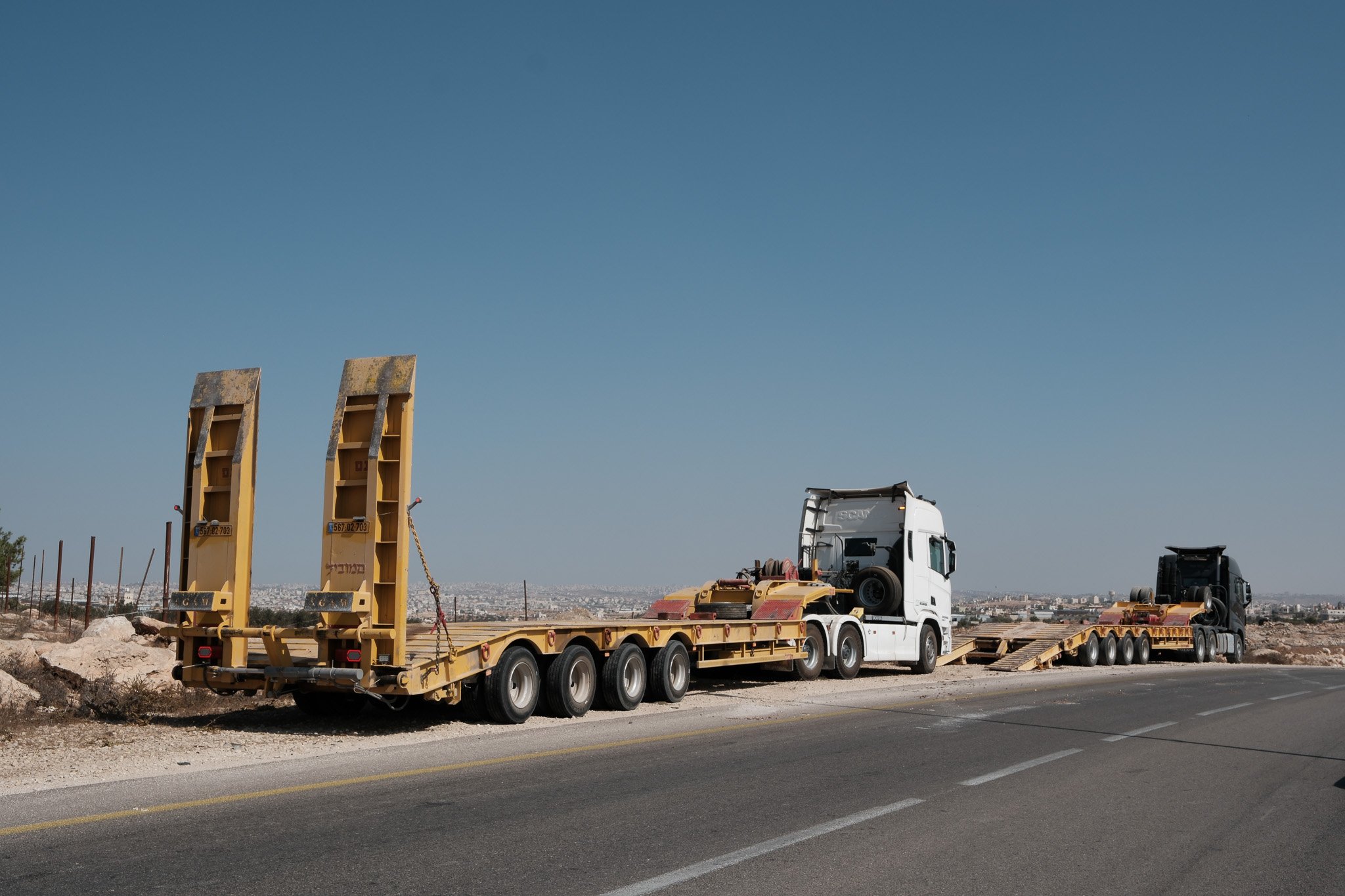 The demolition vehicles are transported under armed guard on the back of two flat-bed lorries. Often the first indication a demolition is imminent is a sighting of a convoy on the main road.