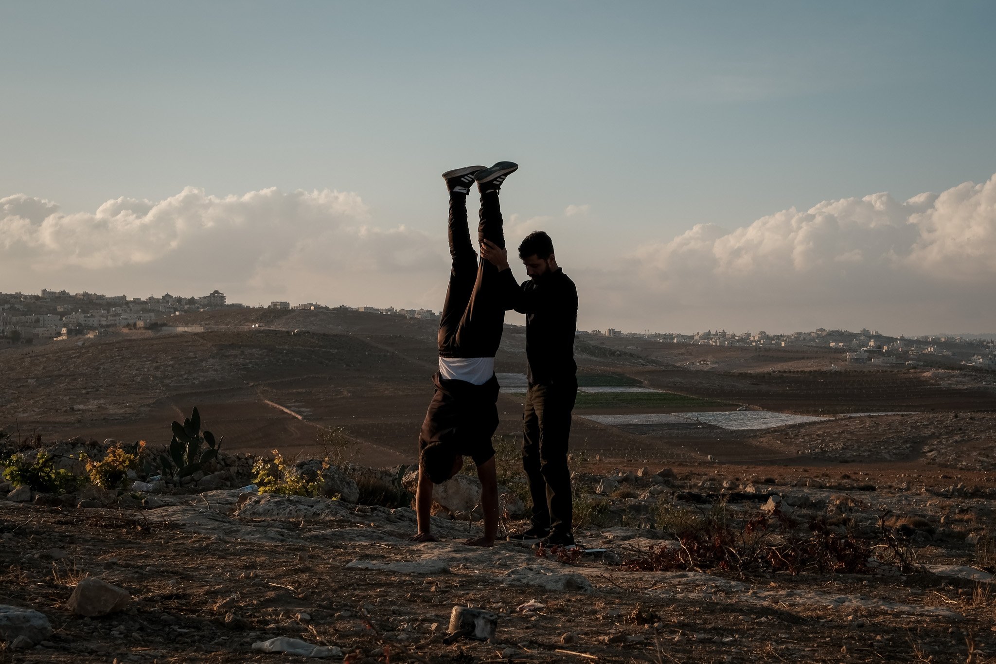 With guns and mobile phones trained on them, and with nowhere to go, the Hureini cousins practice handstands in a gesture half defiant, half bored. An hour after they were detained, and once the settlers had finally left the land, the Hureinis are r