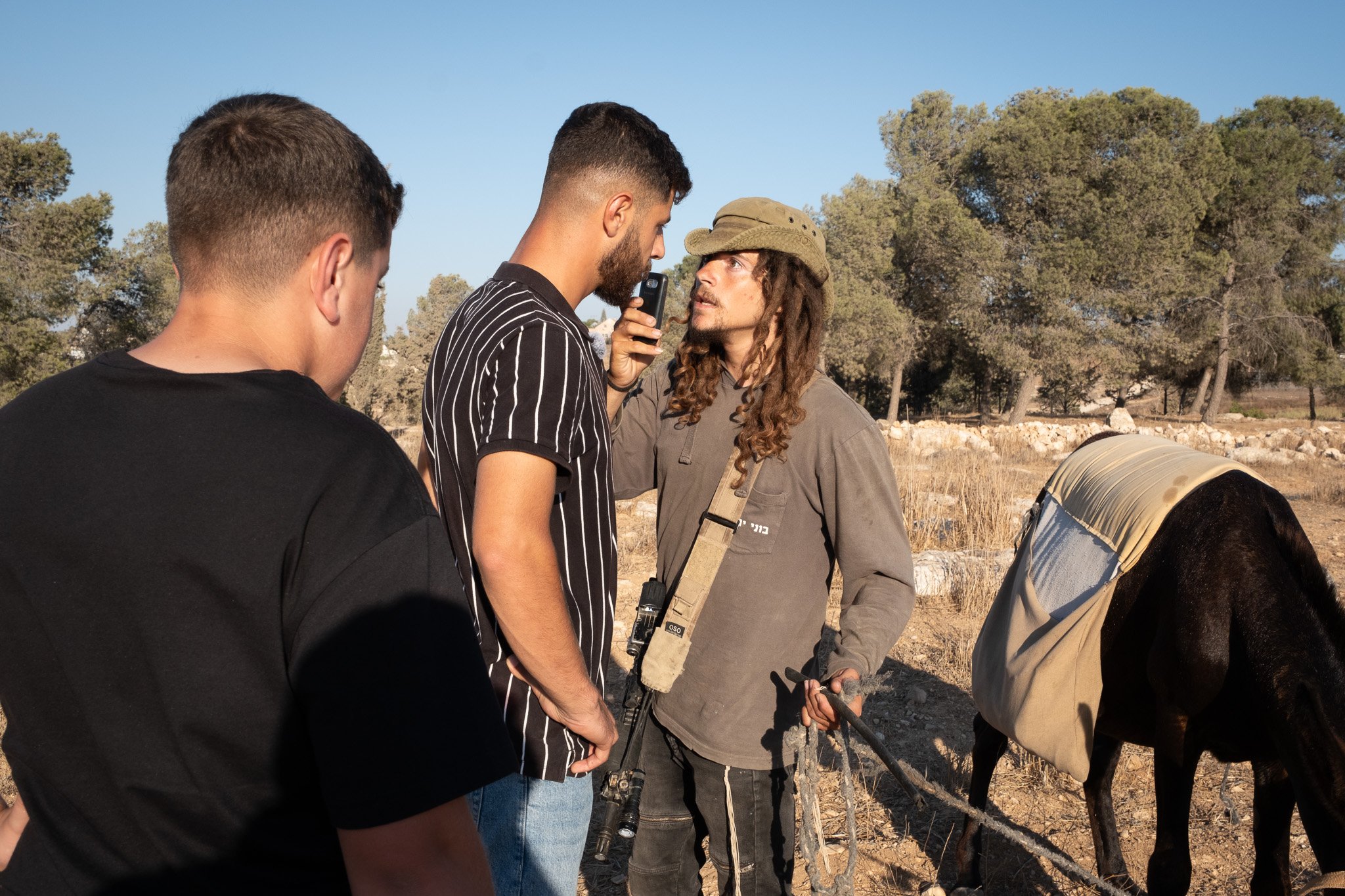 The settler squares up to up Mohammad recording him on his phone.
