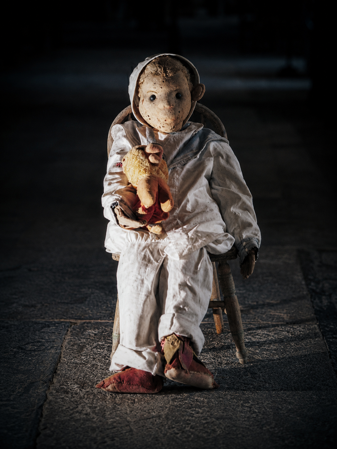 Robert the Doll seated in his chair holding his stuffed lion during Robert the Doll After Dark in Key West.
