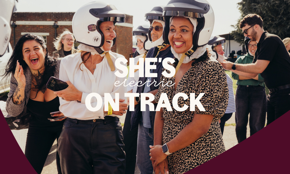 She's Electric On Track event logo overlaid on women at race track laughing