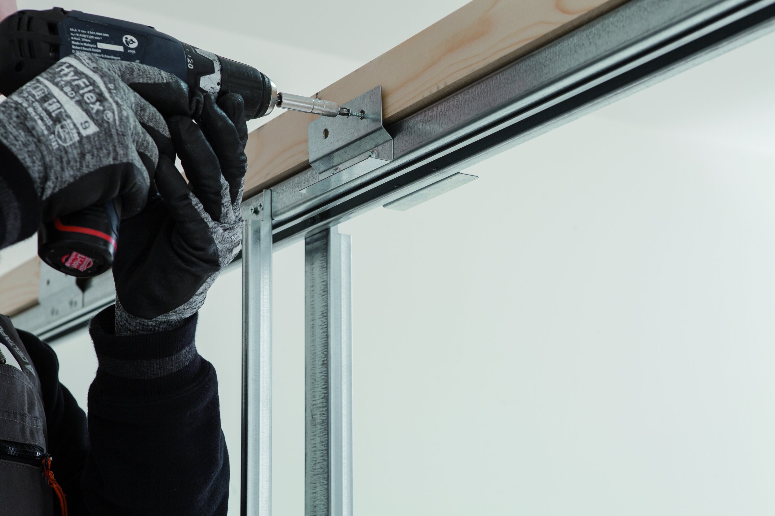 drilling bracket onto stud work to install pocket door frame