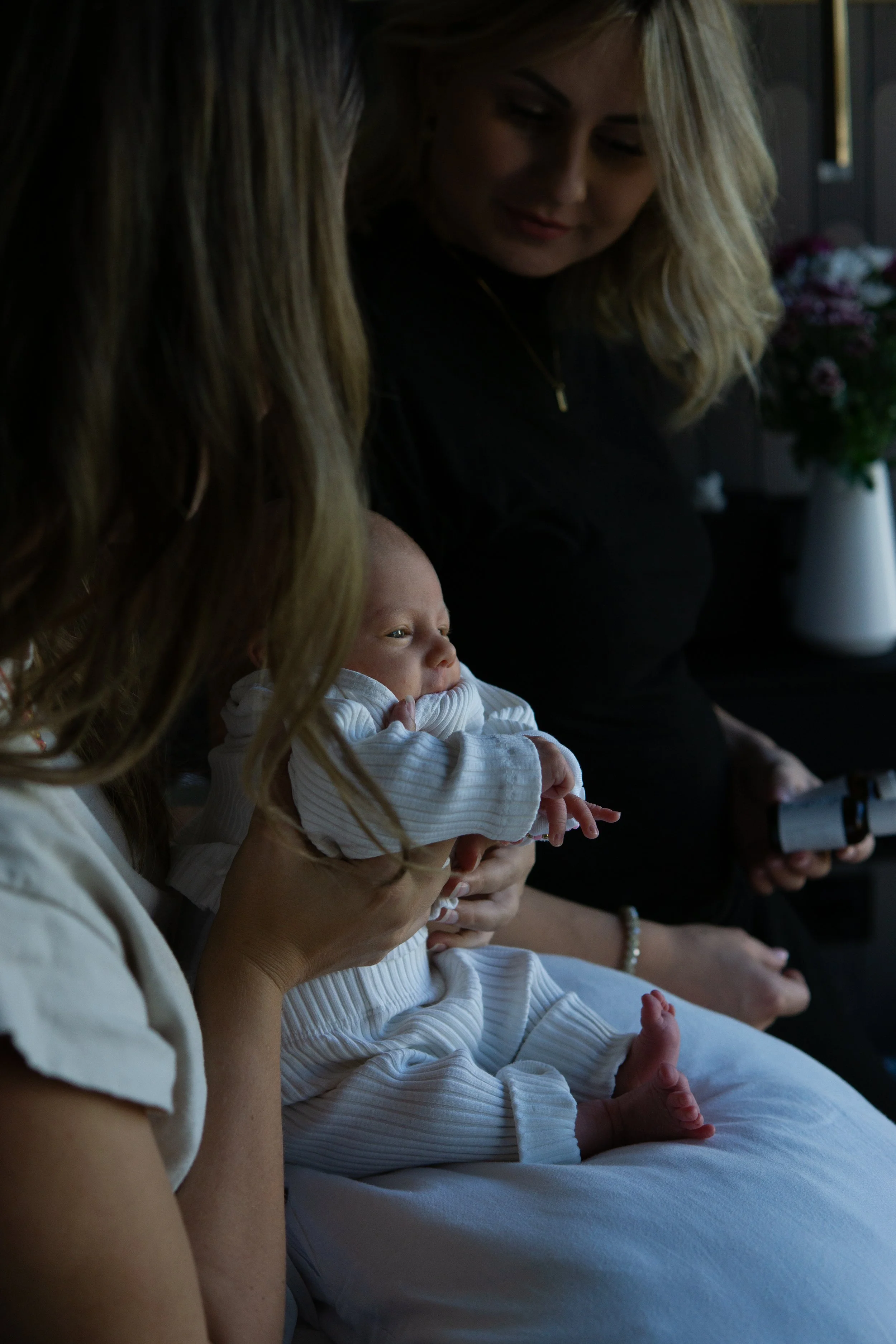 Eine Hebamme berät eine junge Mutter während der Wochenbett-Nachsorge zu Hause