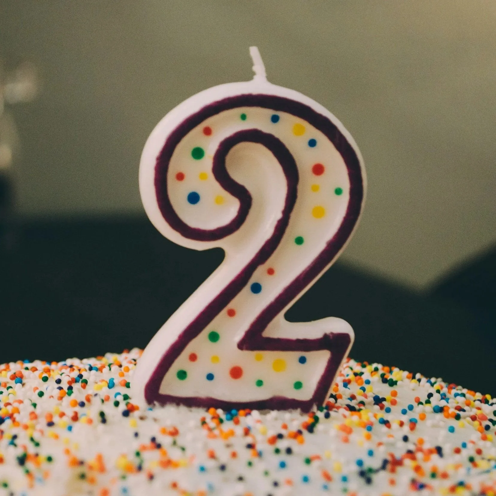 Pink ceramic piggy bank with black eyes and a snout, on a white background.