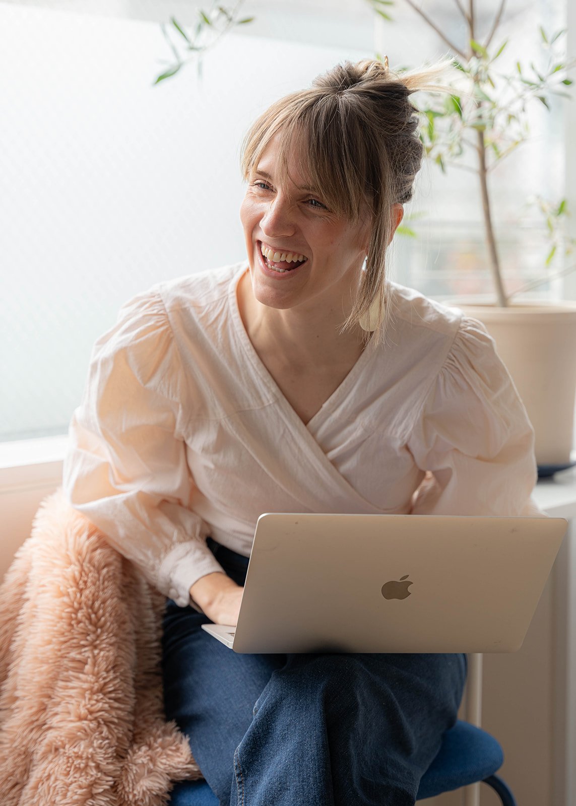 Laughing-by-window-with-laptop.jpg