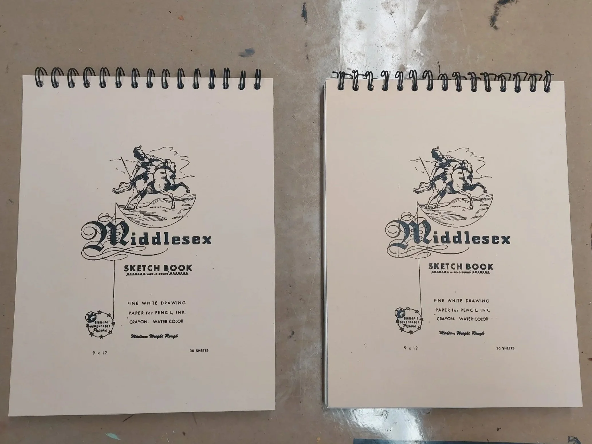 Two copies of a sketchbook with pencil and “charcoal” (crayon) drawings. Cover recreated from reference before being printed and applied to new books.