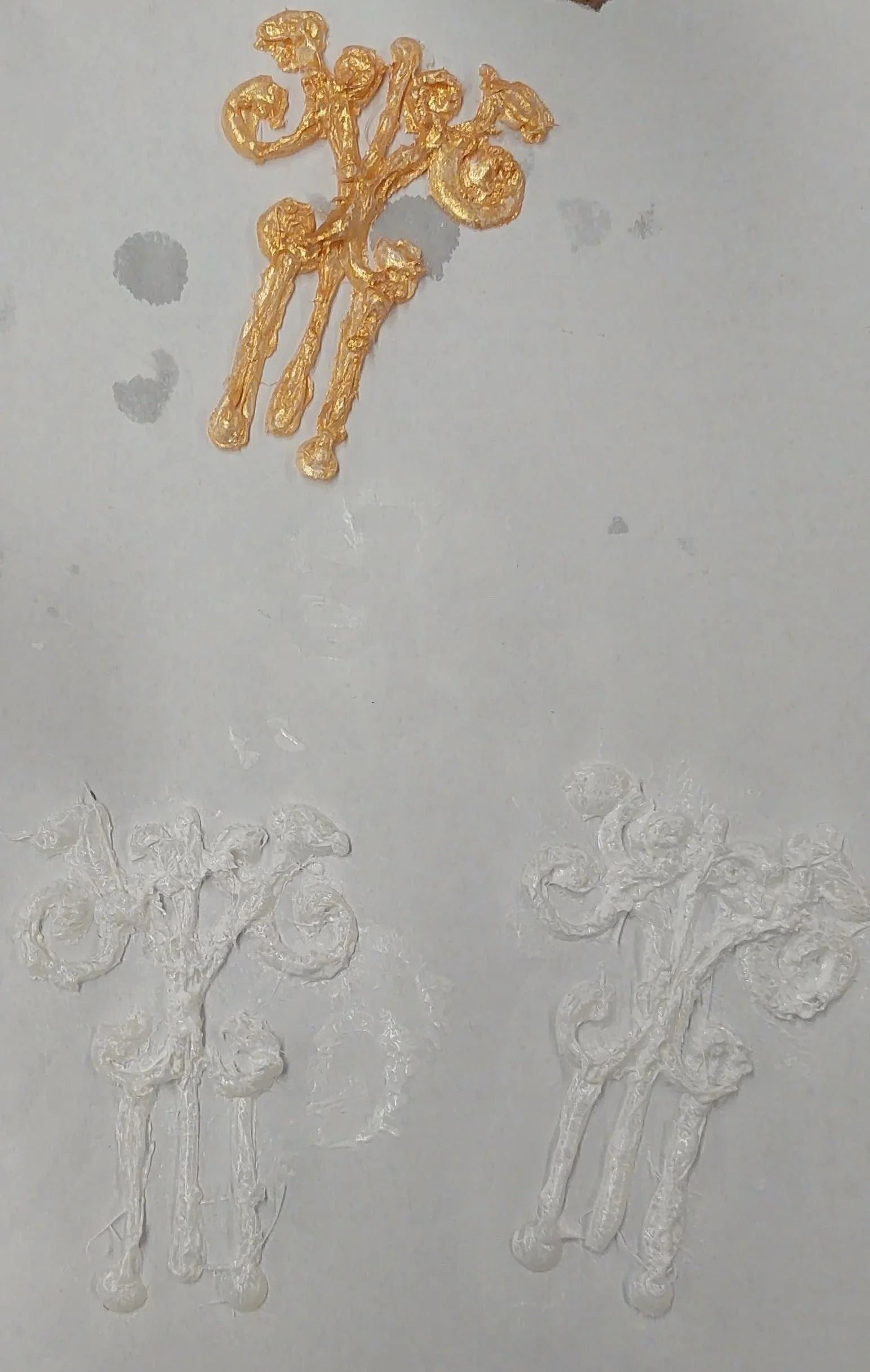 The designs, once removed from the wax paper were primed and painted gold, before being glued to a premade plastic bottle.